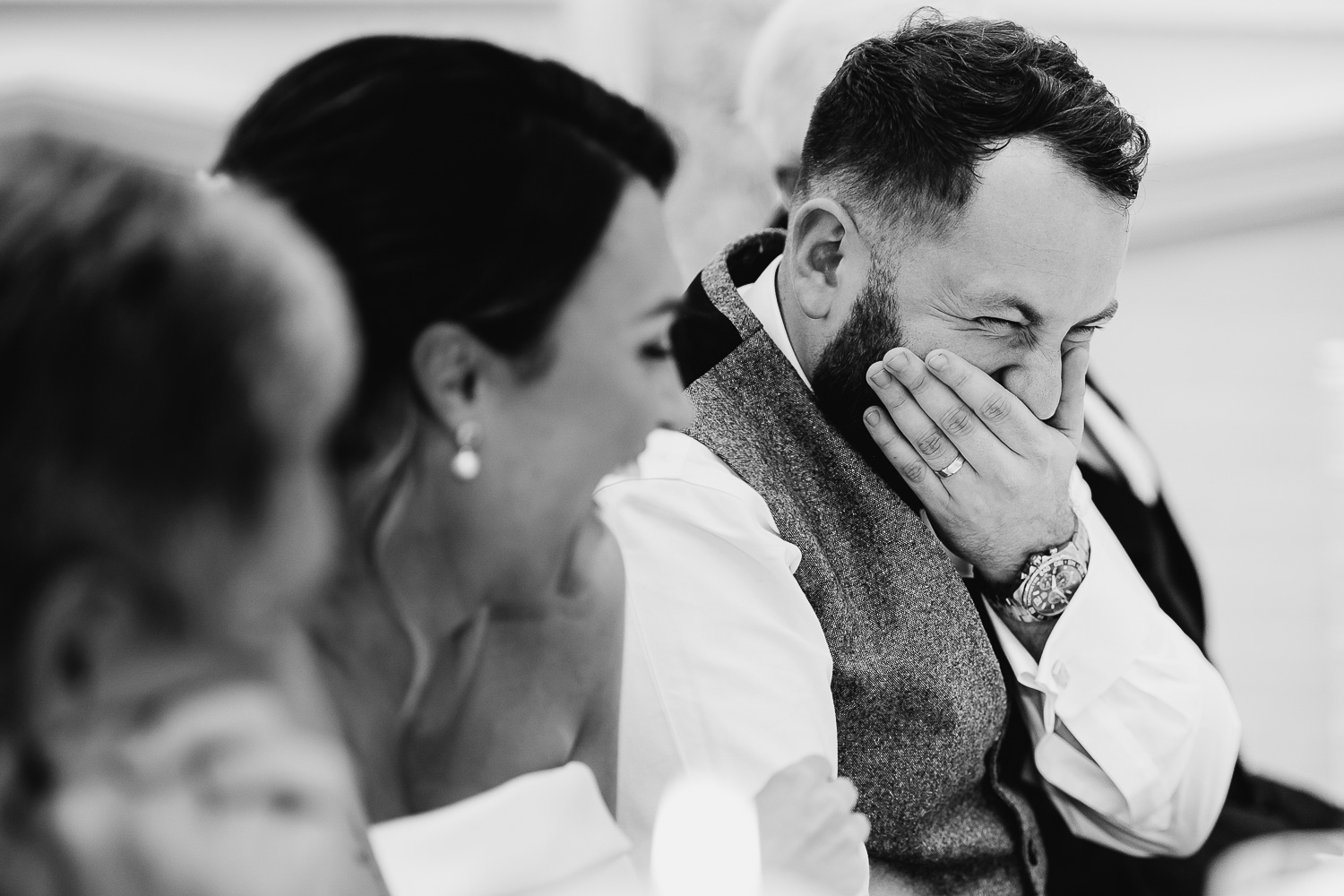 Groom laughing during speeches