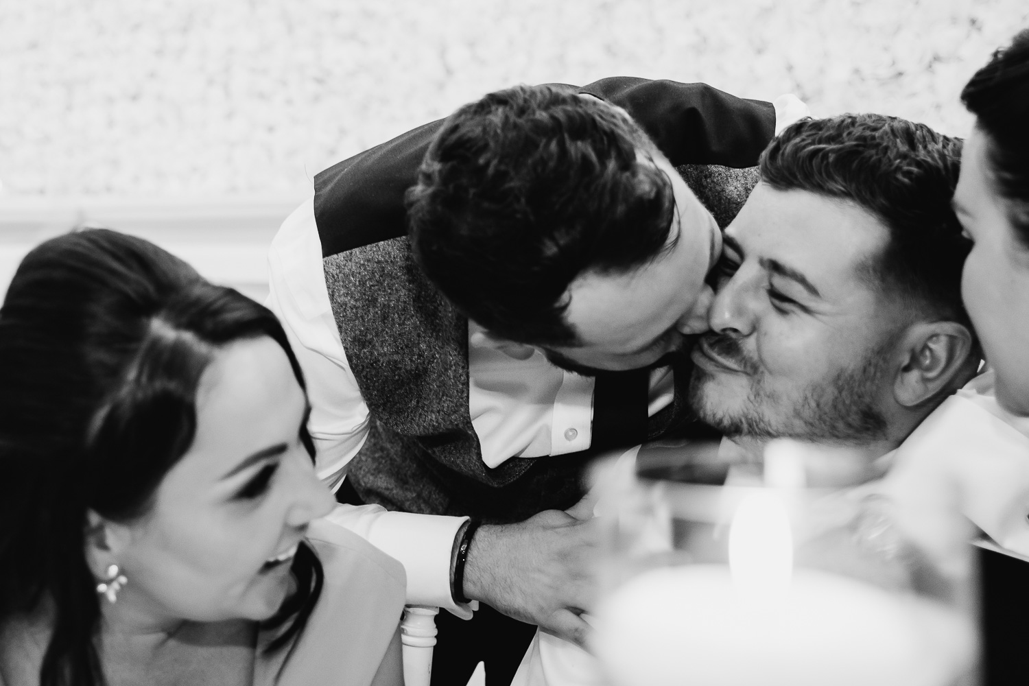 Groom kissing best man