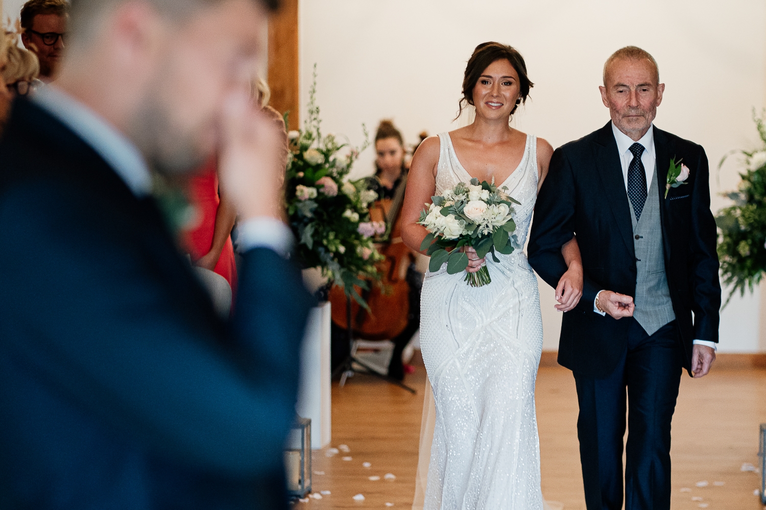 Groom crying with bride walking down aisle
