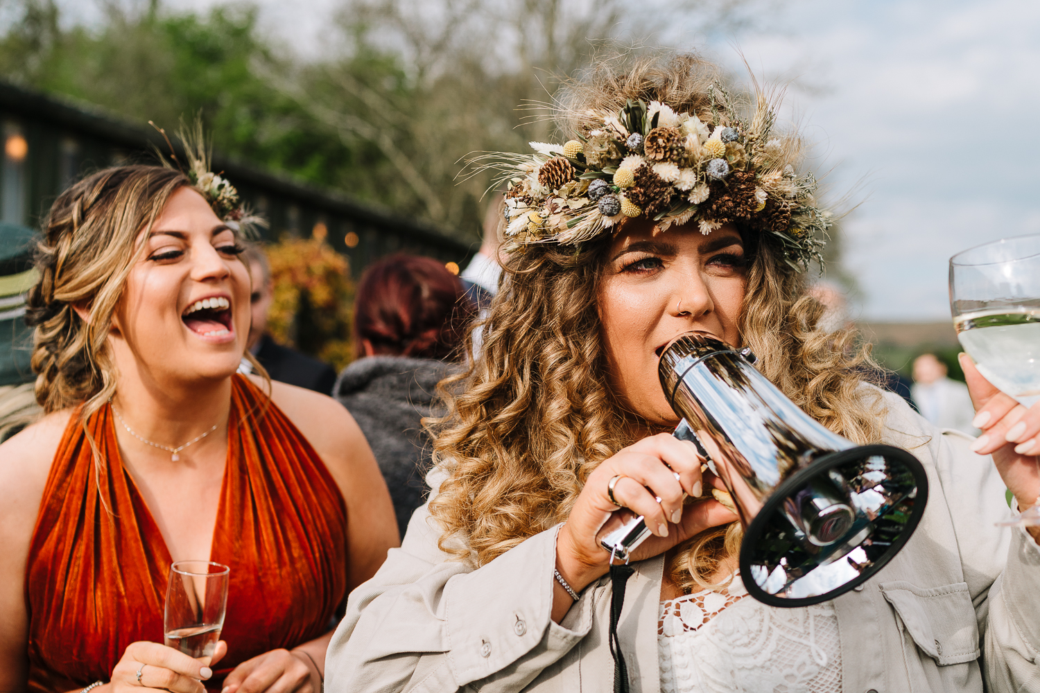 Bride and bridesmaid laughing with a speaker