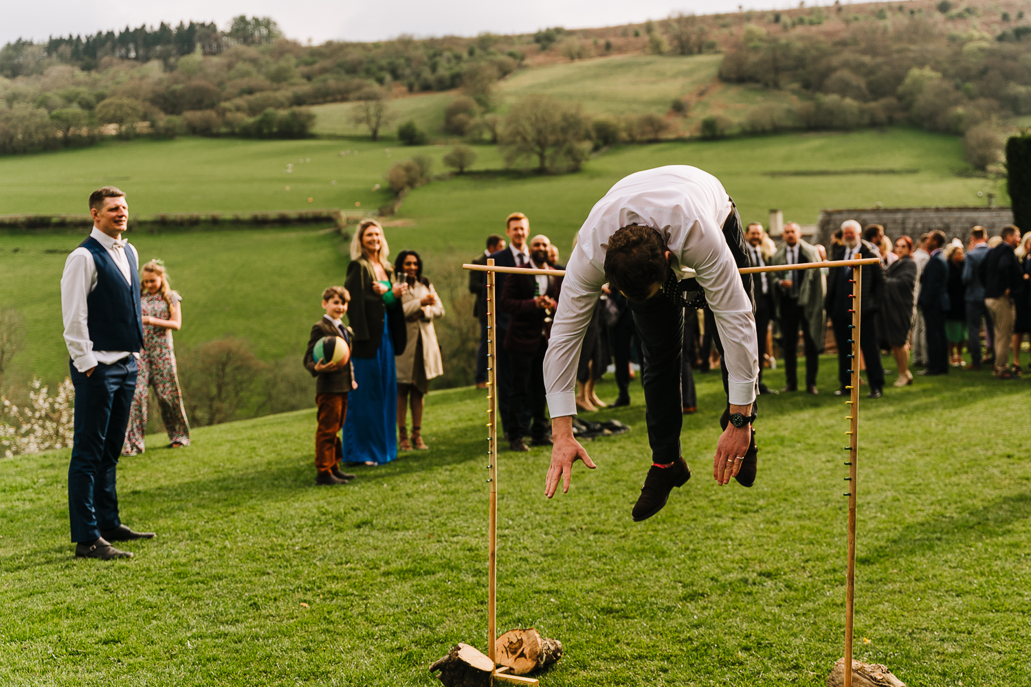 Groom jumping over a pole